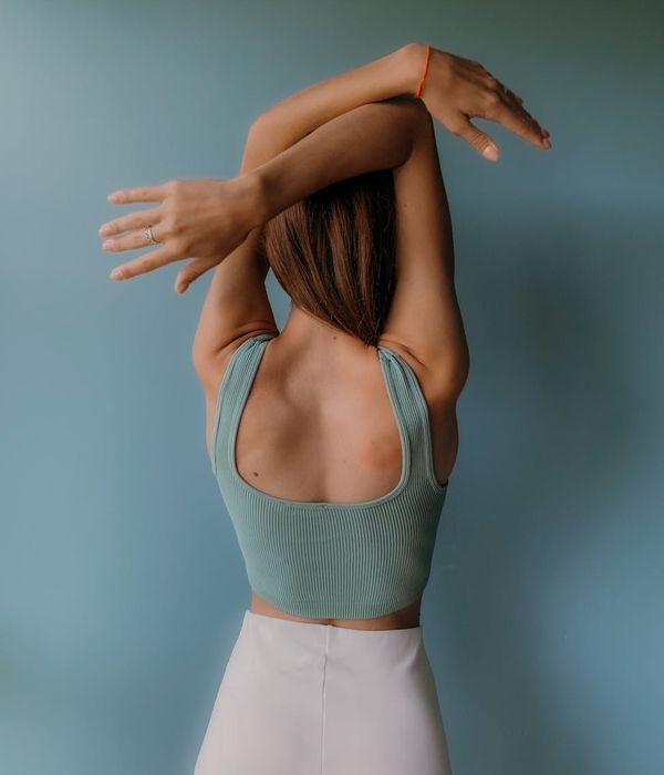 Woman in a graceful yoga pose with mint green light accents.